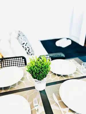 a table with white plates and a potted plant on it at Studio com vista para Rua da Oura - Albufeira in Albufeira