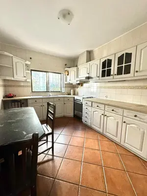 a kitchen with white cabinets and a table and chairs at Fabulous Praia dos Pescadores in Albufeira