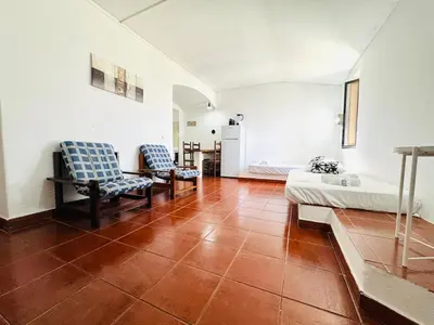 a room with two chairs and a bed and a refrigerator at Apartamento aconchego T1 Rua da Oura in Albufeira