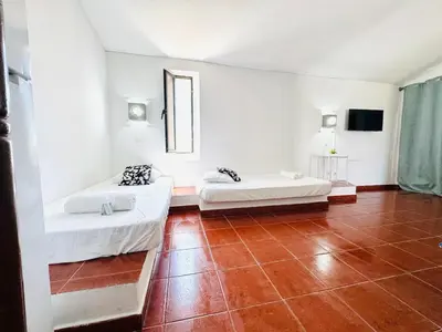 a room with two beds and a tiled floor at Apartamento aconchego T1 Rua da Oura in Albufeira