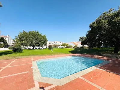 a small swimming pool in a yard with a field at Apartamento aconchego T1 Rua da Oura in Albufeira