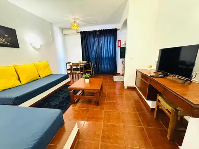 a living room with a couch and a flat screen tv at Apartamento albufeira T1 condominio vila nova in Albufeira