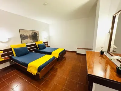 a bedroom with two beds with yellow and blue pillows at Apartamento albufeira T1 condominio vila nova in Albufeira