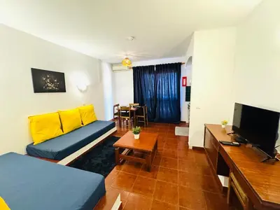 a living room with a couch and a television at Apartamento albufeira T1 condominio vila nova in Albufeira