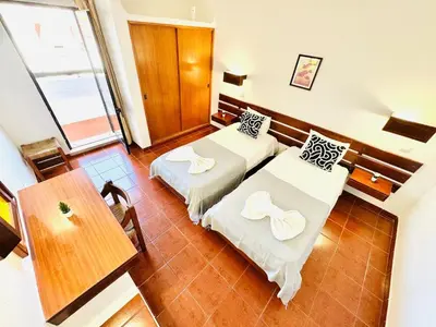 a hotel room with two beds and a table at Condominio privado T1 Rua da Oura in Albufeira