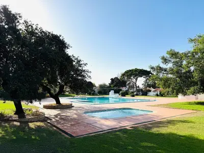 a swimming pool in a yard with trees at Condominio privado T1 Rua da Oura in Albufeira