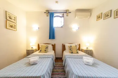 two beds in a small room with a window at Villa Monte Domingos Simoes in Albufeira