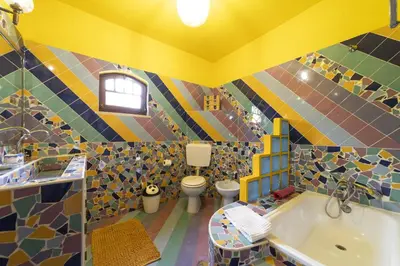 a colorful bathroom with a tub and two toilets at Villa Monte Domingos Simoes in Albufeira