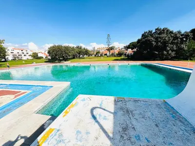an empty swimming pool with blue water in a park at Condominio vila nova T1 Rua da Oura in Albufeira