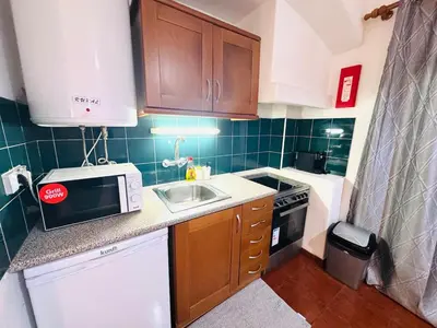 a small kitchen with a sink and a microwave at Condominio vila nova T1 Rua da Oura in Albufeira
