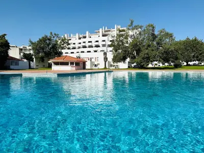 a large pool of blue water in front of a building at Condominio vila nova T1 Rua da Oura in Albufeira