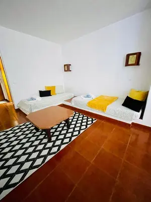 a room with two beds and a table in it at Resort Albufeira T1, Oura Beach in Albufeira