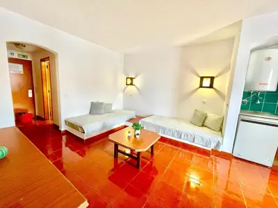 a room with two beds and a table in it at Resort Albufeira T1, Oura Beach in Albufeira
