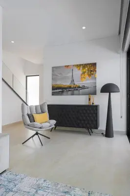 a living room with a chair and a painting on the wall at Villa Clipper in Guia