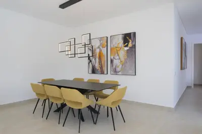 a dining room with a black table and yellow chairs at Villa Clipper in Guia