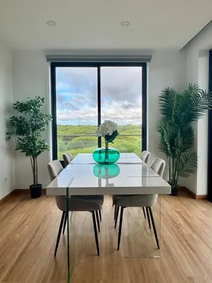 a dining room with a table and chairs and a large window at Sundown Pines Vilamoura in Quarteira