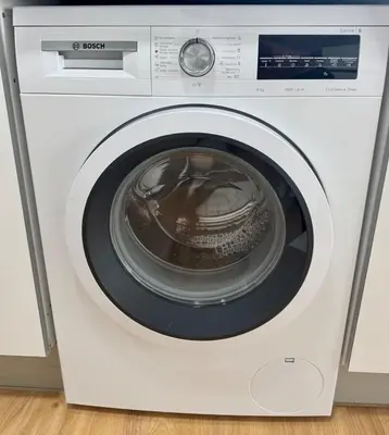 a white washing machine with its door open at Sundown Pines Vilamoura in Quarteira