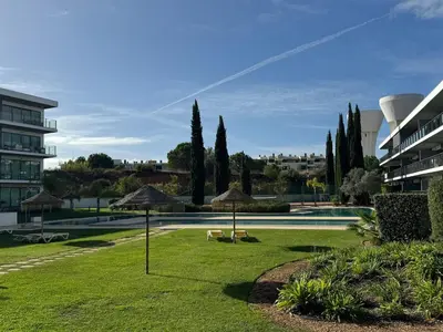 a park with umbrellas and a swimming pool at Sundown Pines Vilamoura in Quarteira