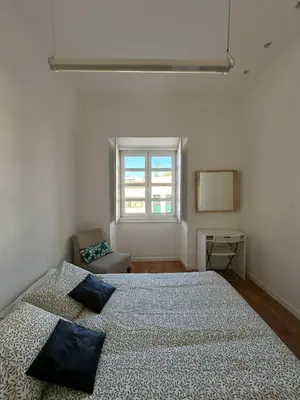 a white bedroom with a bed with pillows on it at Casa das Oliveiras in Faro