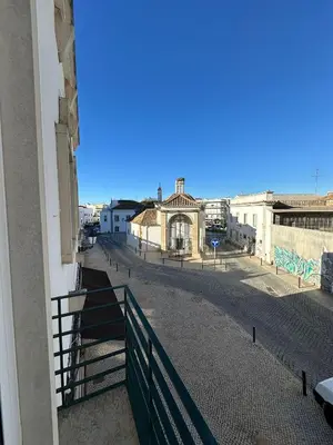 a white bedroom with a bed and a mirror at Casa das Oliveiras in Faro