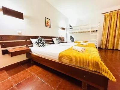 a bedroom with a large bed with a yellow blanket at Resort Albufeira T1, Oura Beach in Albufeira