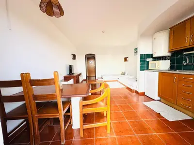 a kitchen with a table and chairs in a room at Studio Vila Nova in Albufeira