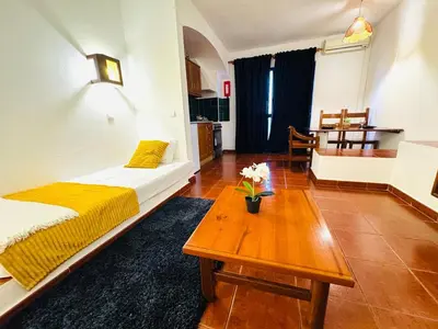 a living room with a bed and a coffee table at Studio Vila Nova in Albufeira