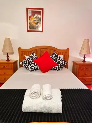 a bedroom with a bed with two lamps and two towels at Red Apartament Praia da Oura in Albufeira