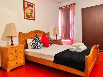a bedroom with a wooden bed with pillows and a window at Red Apartament Praia da Oura in Albufeira