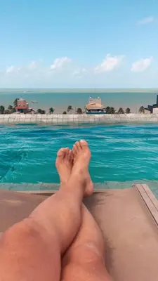 a man laying on the edge of a swimming pool at Resort Albufeira T2, Oura Beach in Albufeira