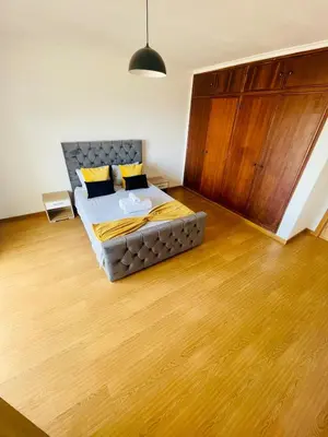 a bedroom with a bed and a wooden floor at Duplex Apartment Albufeira in Albufeira