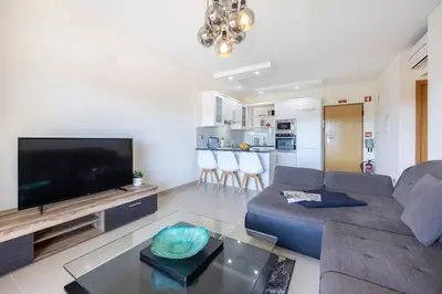 a living room with a couch and a flat screen tv at Almargem Apartment in Quarteira