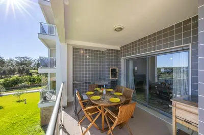 a dining room with a table and chairs on a balcony at Almargem Apartment in Quarteira
