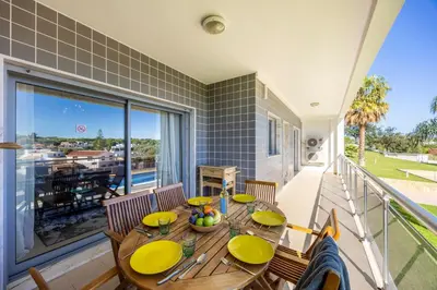 a dining room with a table and chairs on a balcony at Almargem Apartment in Quarteira