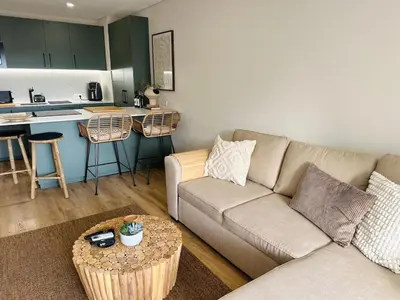 a living room with a couch and a kitchen at The Sun of Quarteira in Quarteira