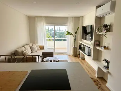 a living room with a couch and a table at The Sun of Quarteira in Quarteira