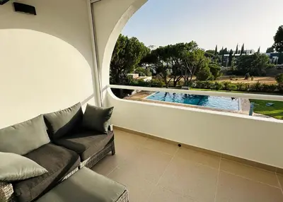 a living room with a couch and a view of a pool at The Sun of Quarteira in Quarteira