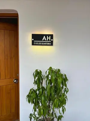 a sign on a wall next to a plant at The Sun of Quarteira in Quarteira