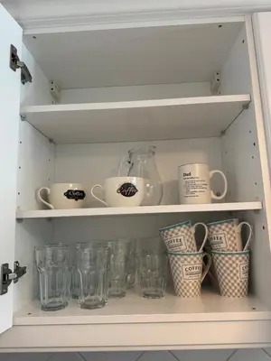 a shelf with cups and cups on it at Lovely 3 Bedroom Home in a Resort in Albufeira in Albufeira