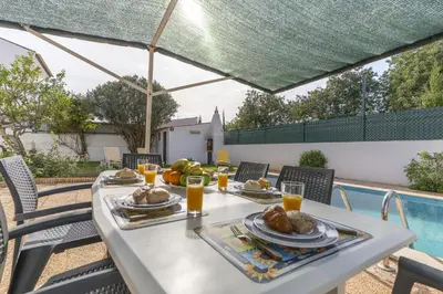 a swimming pool with a table and chairs next to a house at #350 Retiro do Abade by Home Holidays in Ferreiras