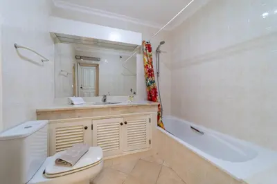 a bathroom with a toilet and a tub and a sink at My Inzu by HelloVacations in Albufeira