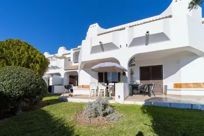 a white house with a patio and lawn at My Inzu by HelloVacations in Albufeira
