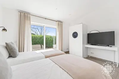 a white bedroom with two beds and a window at Villa Benjamin - Vale do Lobo in Vale do Lobo