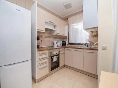a small kitchen with white cabinets and a sink at Akisol Albufeira Orion in Albufeira