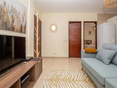 a living room with a blue couch and a tv at Akisol Albufeira Orion in Albufeira
