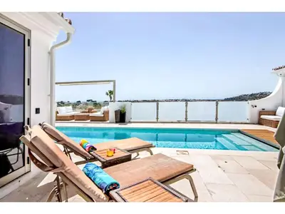 a pool with two chairs and a table next to a swimming pool at Holiday Home Gina - Sunny Way by Interhome in Albufeira