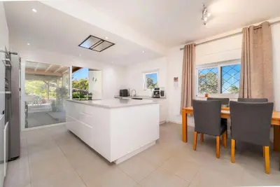 a kitchen with a large island with stools at Casa Colina Sonolenta in Fonte da Murta