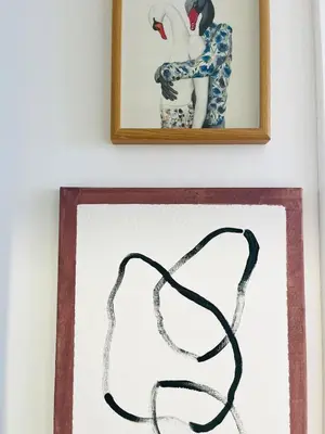 a painting of a black wire on a wall next to two pictures at Casa Nico in Faro