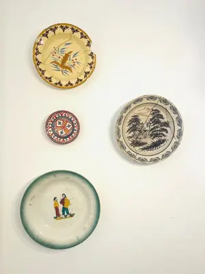 a group of plates on a white wall at Casa Nico in Faro