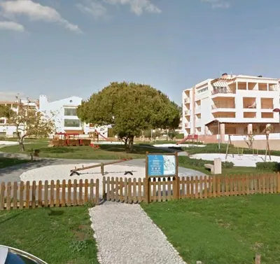 a wooden fence with a sign in front of a building at vista golf in Quarteira